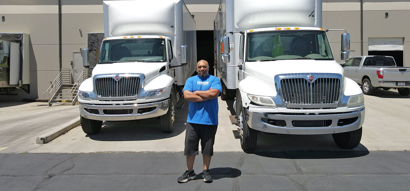 Meyer employee standing with Meyer trucks